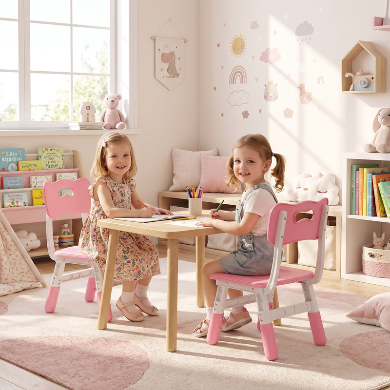 Two girls at a wooden table on kids chairs, with a bookcase and toys behind