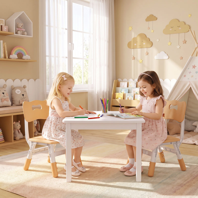 Two girls colouring at a table on kids chairs in a playroom with a play tent