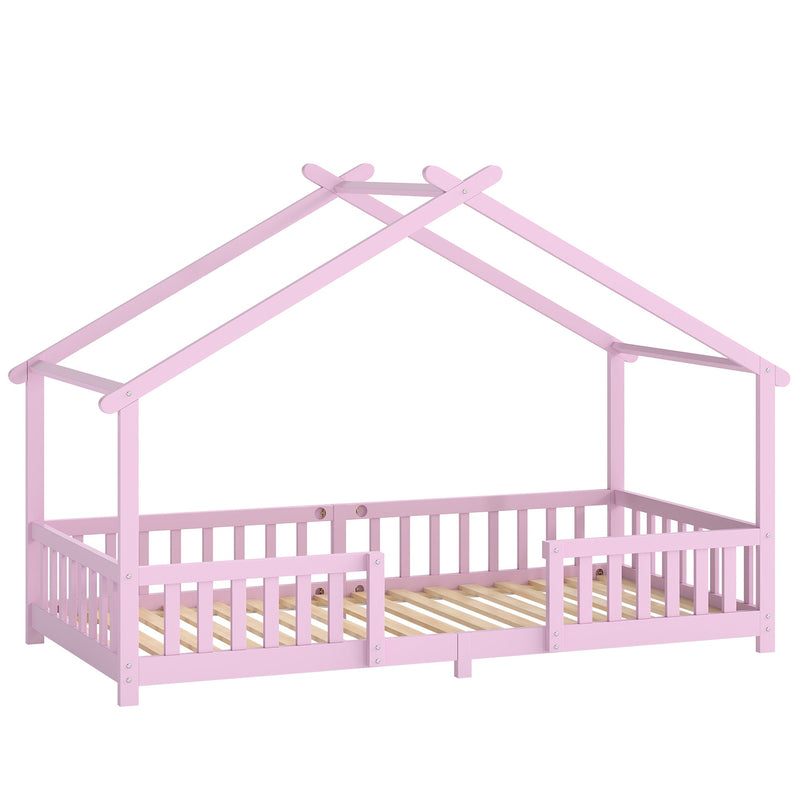 Pink wooden kids house bed frame with peaked roof and dual guardrails, studio shot