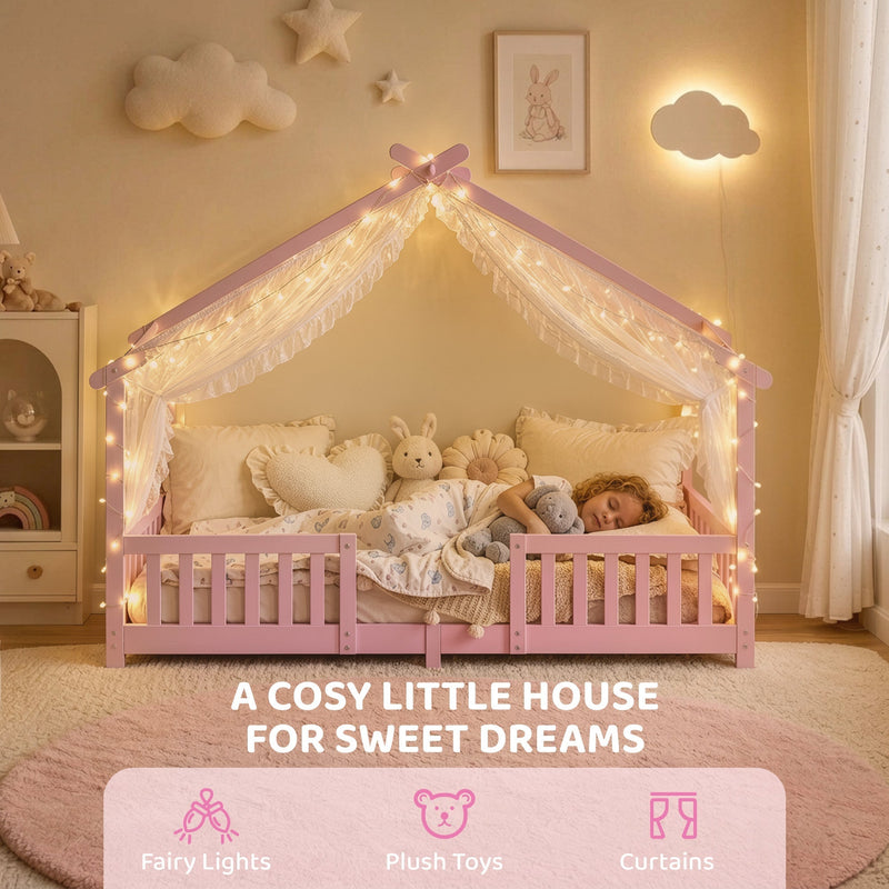 Child asleep in the pink house bed frame decorated with fairy lights and plush toys