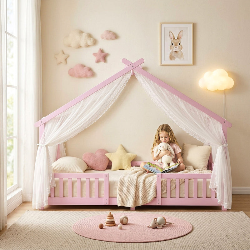 Child reading inside the pink house bed frame with sheer canopy drapes