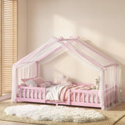 Styled bedroom scene with the pink house bed frame dressed in white and pink bedding