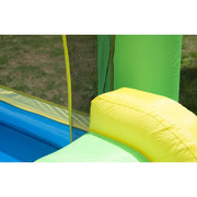 Close-up of the mesh netting, green tower and yellow slide edge on the bouncy castle