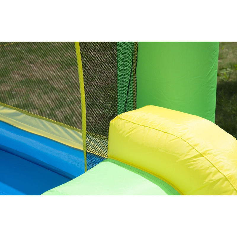 Close-up of the mesh netting, green tower and yellow slide edge on the bouncy castle