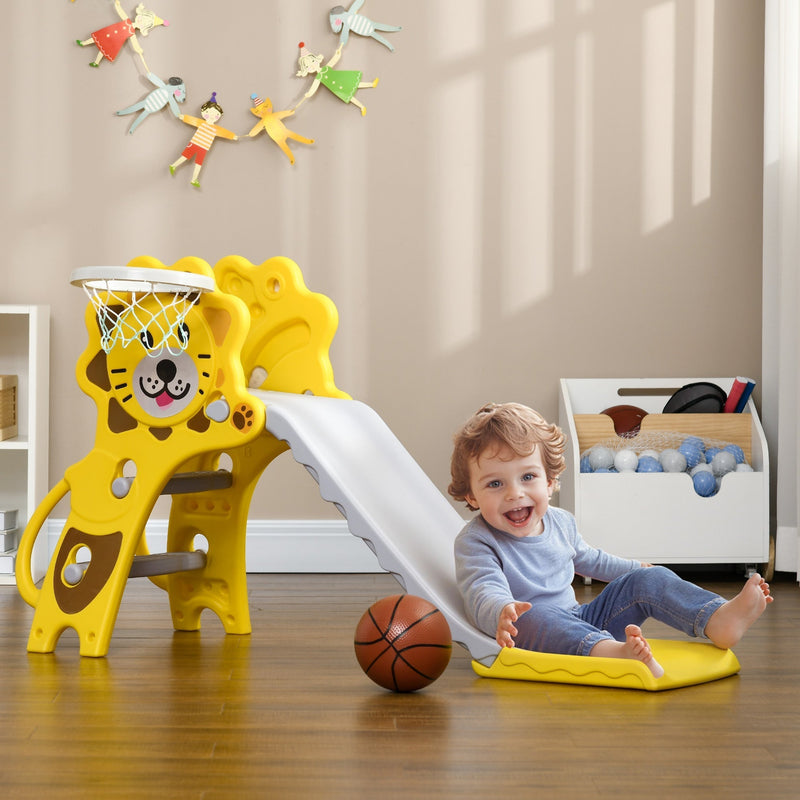 Toddler sitting at the bottom of the yellow Aiyaplay slide with a basketball