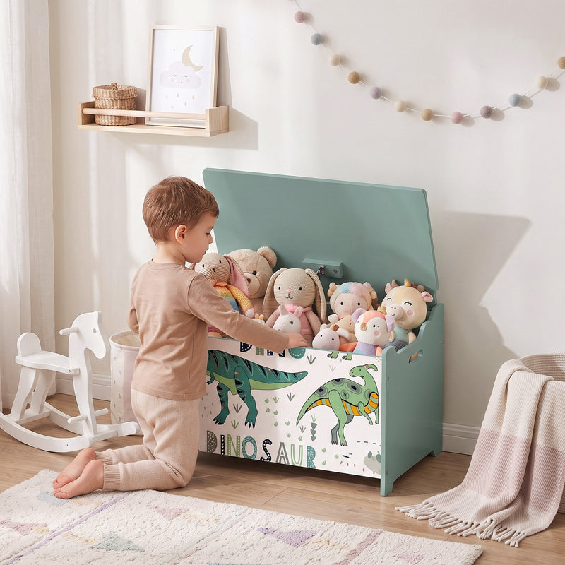 Child putting soft toys into the green dinosaur toy chest in a bedroom