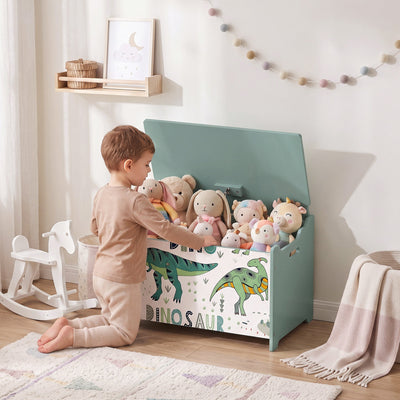 Child putting soft toys into the green dinosaur toy chest in a bedroom