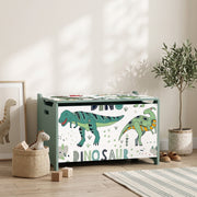 Closed green dinosaur toy chest in a living space beside a basket