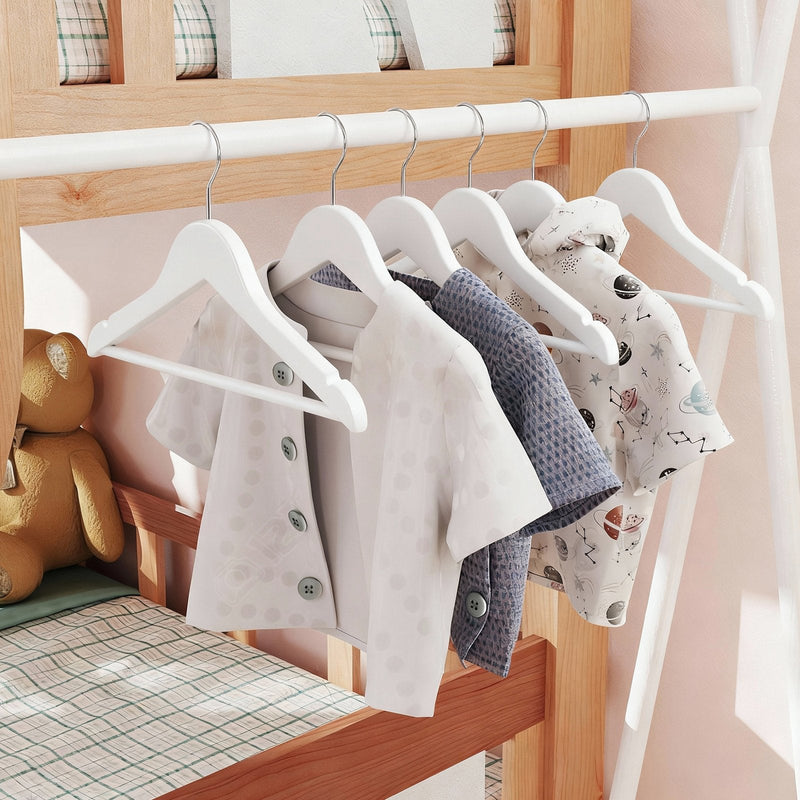 Kids wooden hanger holding a folded top over the trouser bar