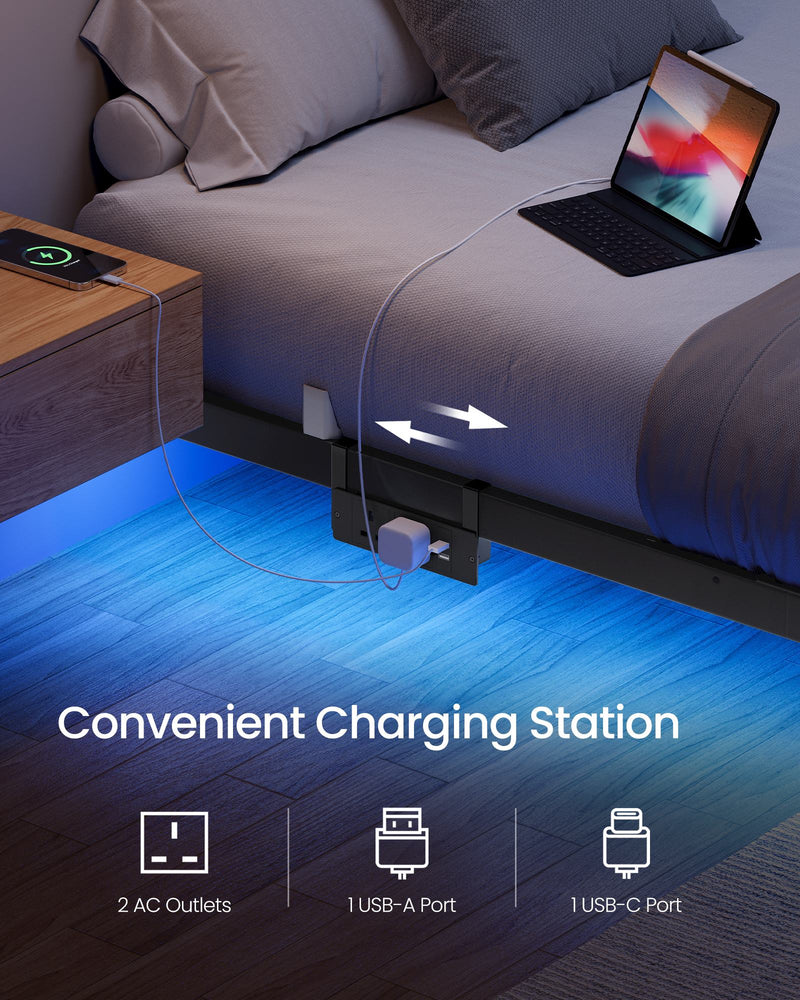 Close-up of the built-in charging station with a phone and tablet plugged in beside the bed
