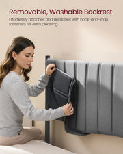 A woman detaching the padded grey backrest cushion from the headboard for washing