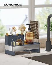 Slate grey sink caddy styled on a kitchen countertop beside a running tap with brushes and soap