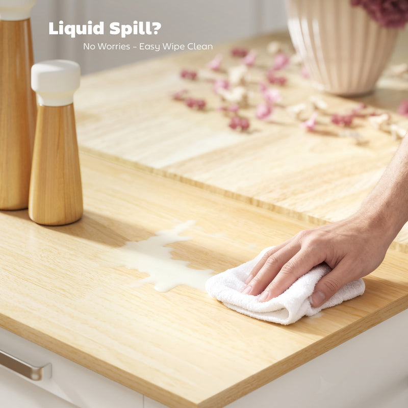 Hand wiping a liquid spill off the wood-effect worktop with a cloth