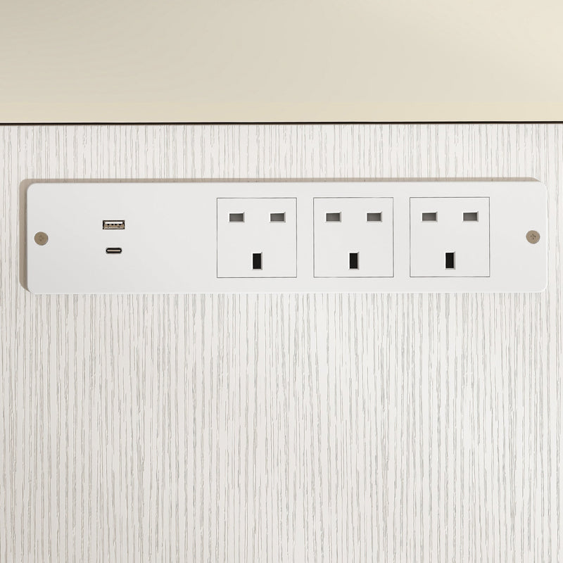Close-up of a phone and earbuds charging from the desk's USB ports