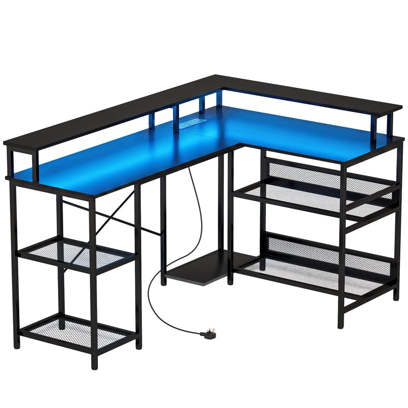 Black L shaped gaming desk with blue LED lighting and two monitor stands on a white background