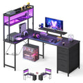 Black L-shaped LED gaming desk with shelf riser and 3-drawer unit, studio view