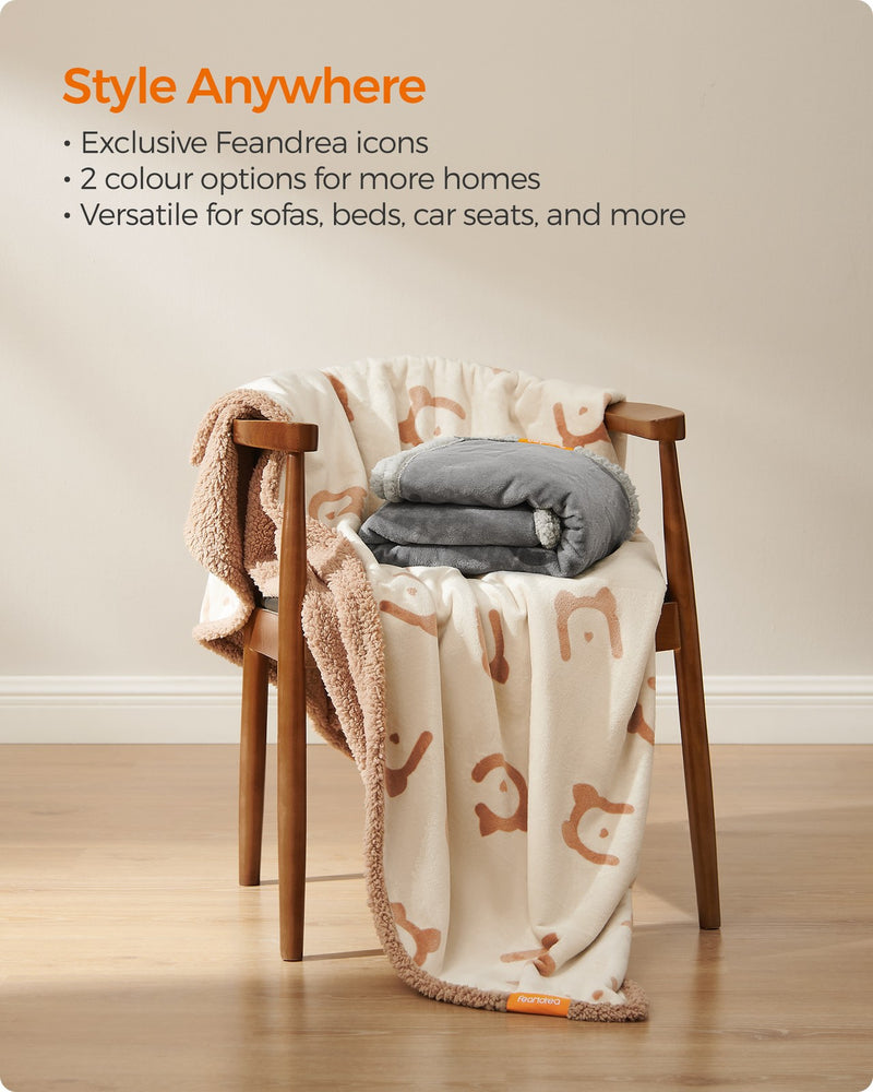 Folded Feandrea dog blanket in beige and grey colour options styled on a wooden chair