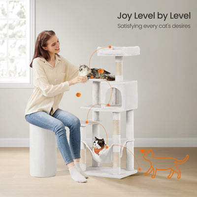 Cat resting inside the hammock on the cream white cat tree