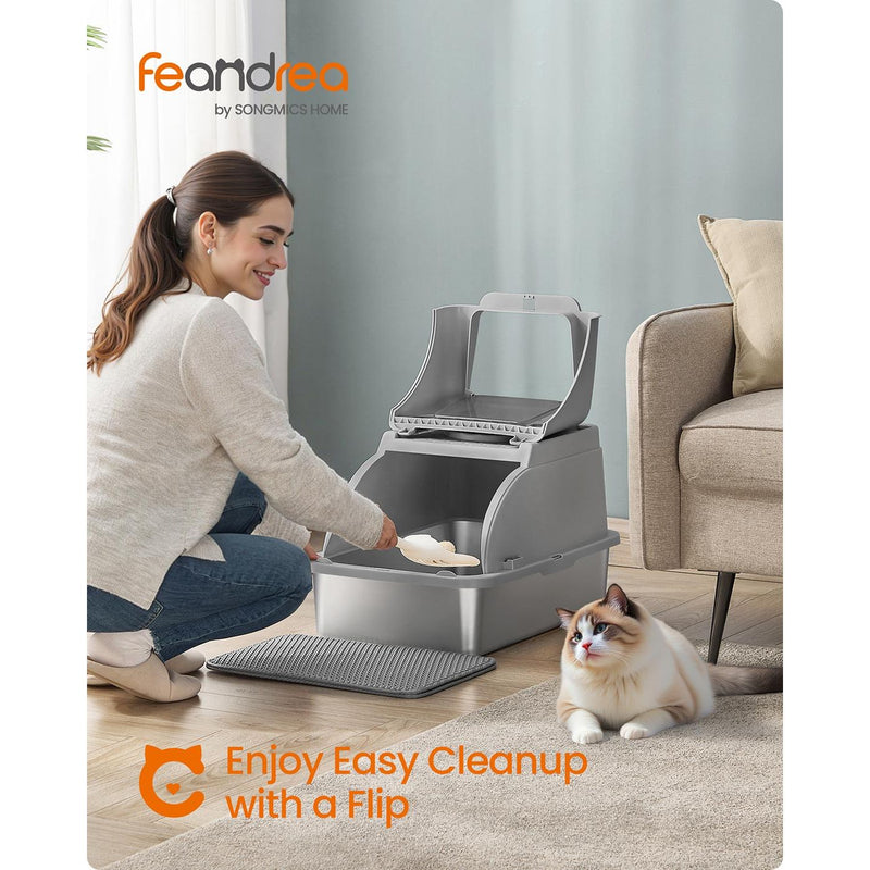 Woman scooping litter through the flip lid of the stainless steel cat litter box in a living room
