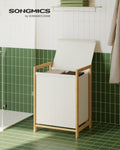 Cream white bamboo laundry hamper with lid open, styled in a bathroom