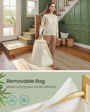 Person carrying the hamper's removable fabric laundry bag by its handles through a hallway