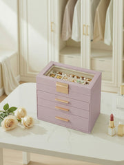 The lavender purple jewellery box on a white dressing table beside cream roses and a lipstick