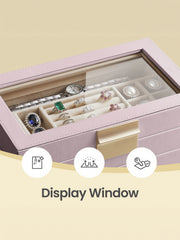 Close-up through the glass lid at the top tray holding a watch, rings and pearl earrings