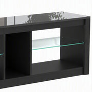 Close-up of the black TV stand's glass shelf and open compartments