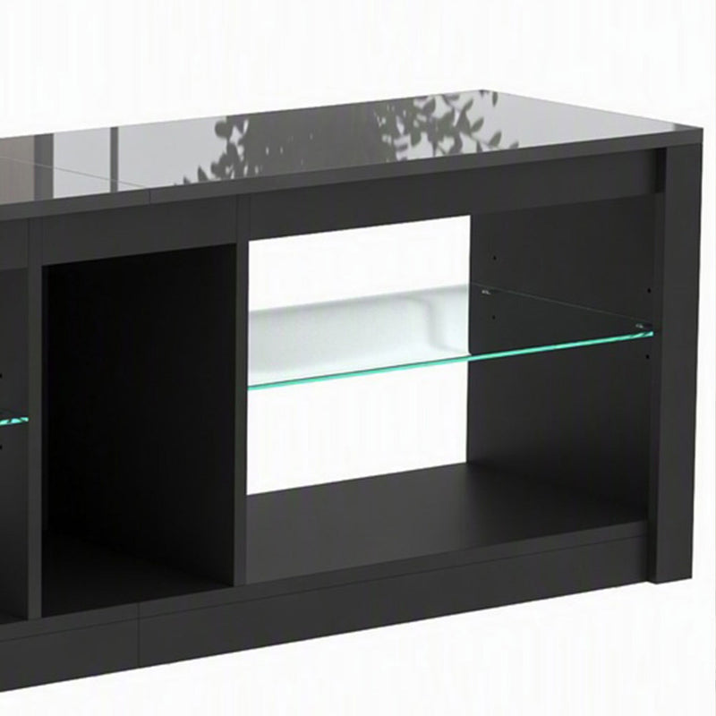 Close-up of the black TV stand's glass shelf and open compartments