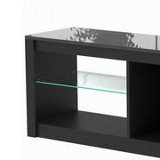 Close-up of the black TV stand's corner with a glass shelf and glossy top
