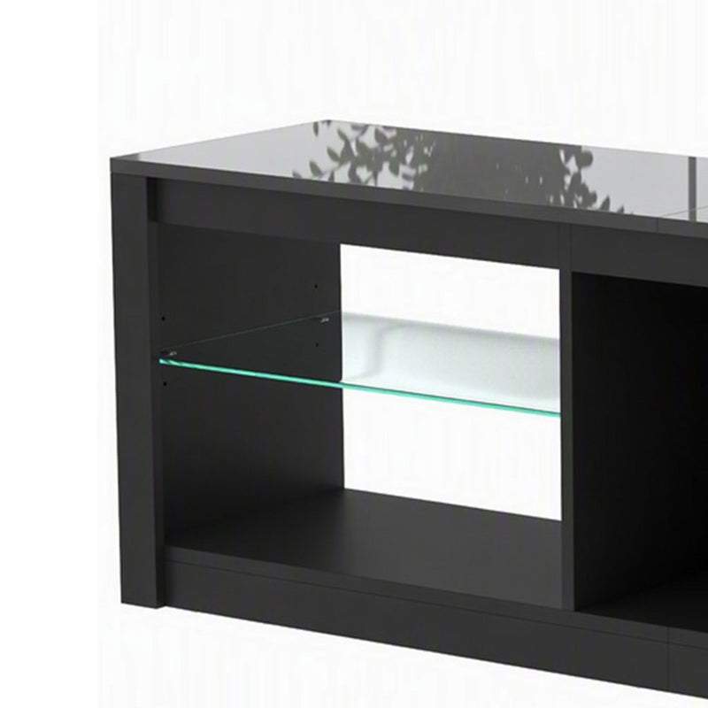 Close-up of the black TV stand's corner with a glass shelf and glossy top