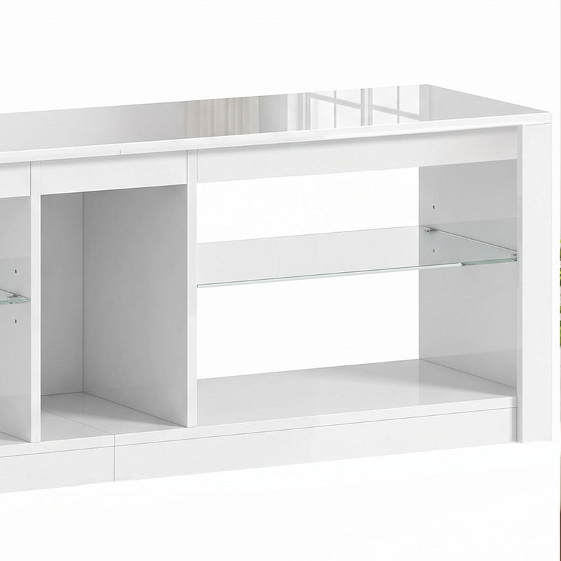 Close-up of the white TV stand's glass shelf and open compartments
