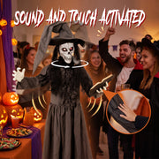 Animated witch decoration with rotating skull face at an indoor Halloween party