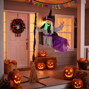 Flying witch decoration set up on a porch decorated for Halloween