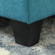 Close-up of the sofa's block foot and light blue fabric texture