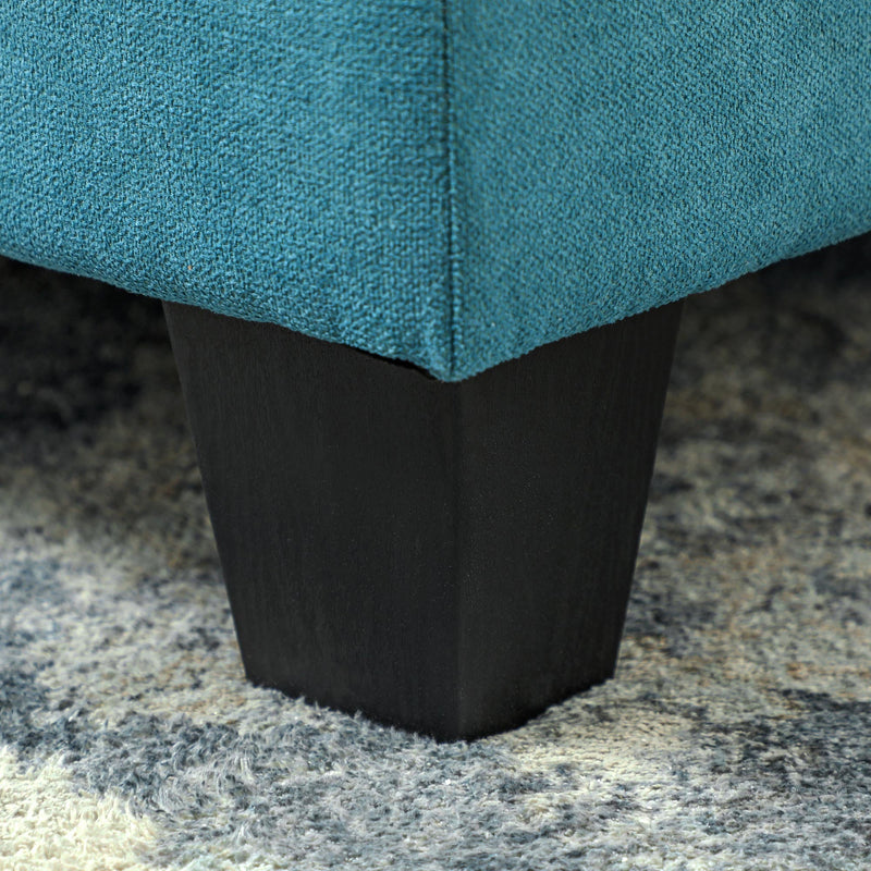 Close-up of the sofa's block foot and light blue fabric texture