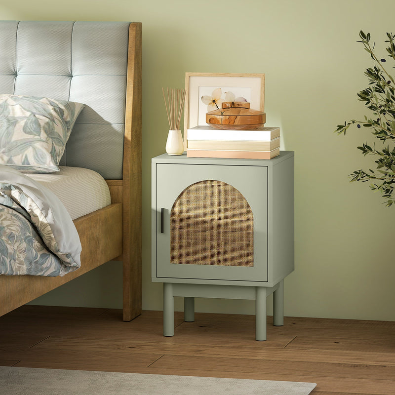 Light green bedside table styled next to a bed with books and a diffuser on top