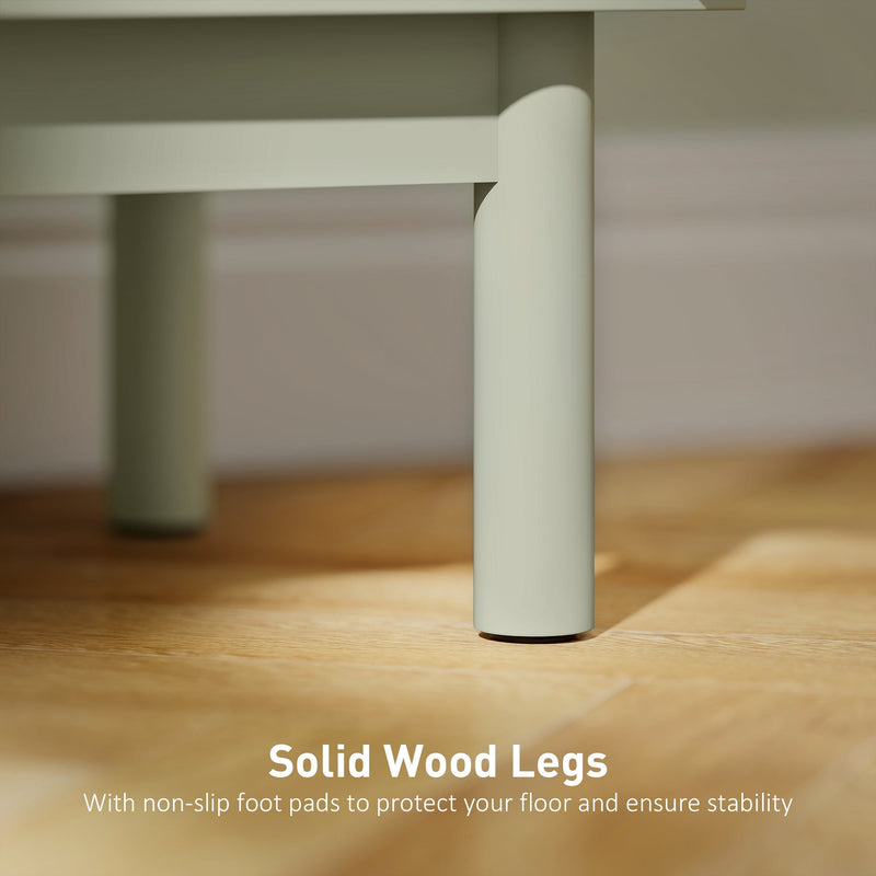 Close-up of a solid wood table leg with non-slip foot pad on a wooden floor