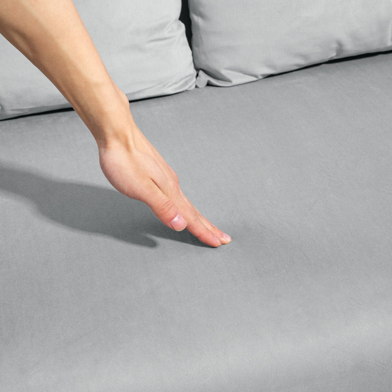 Close-up of a hand pressing into the tufted velvet cushion