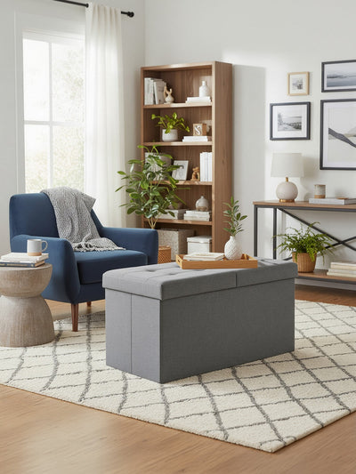 Storage ottoman used as a coffee table styled in a living room with an armchair