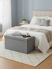 Storage ottoman styled at the foot of a bed with a coffee tray on top