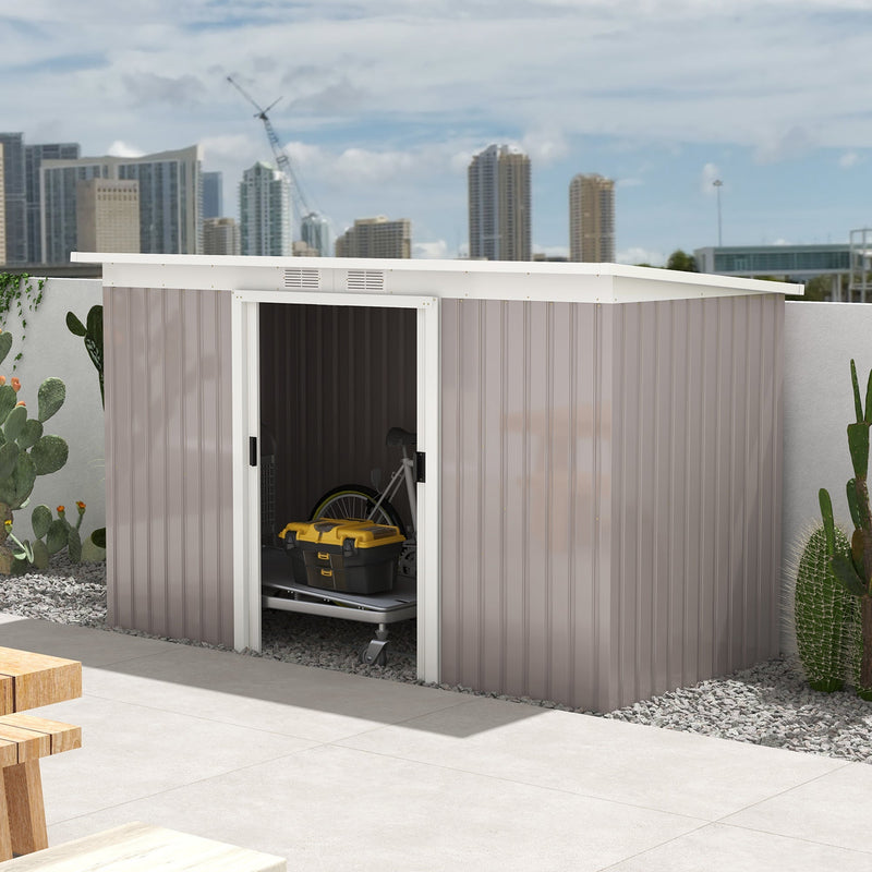 Light grey shed on a terrace with the doors slid open and a bike stored inside