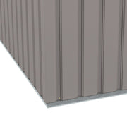 Close-up of the corner where the ribbed wall panels meet the base of the shed
