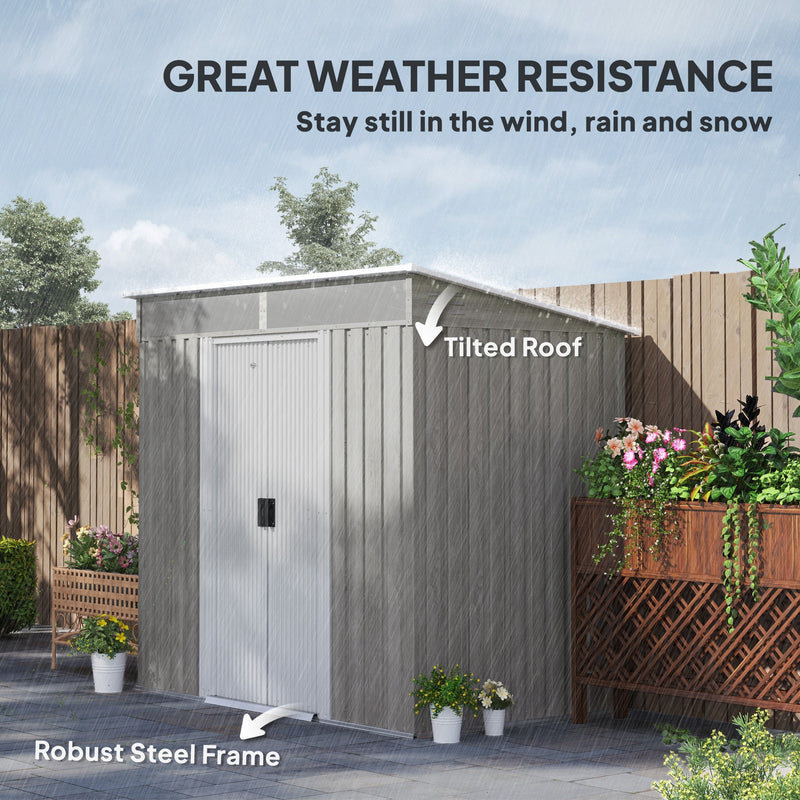 Light grey shed braced against wind and rain, showing the tilted pent roof and steel frame