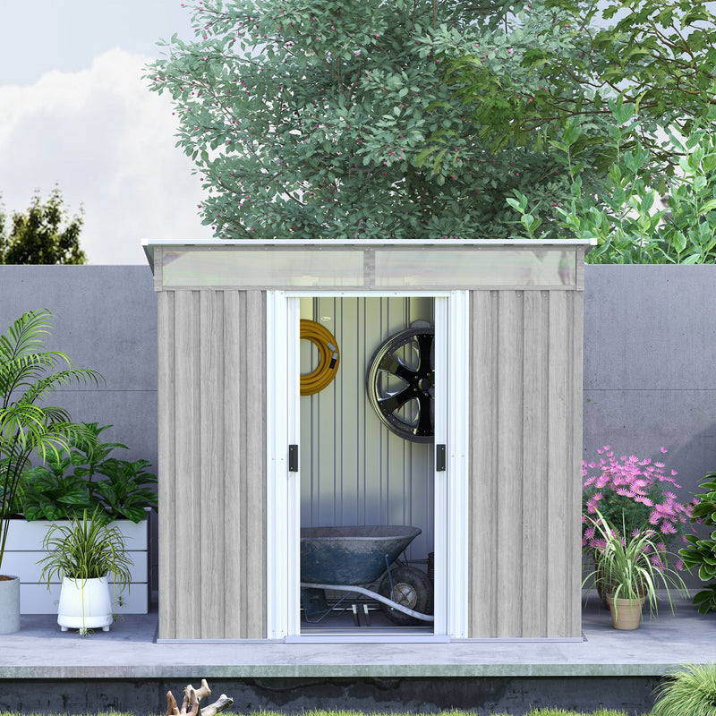 Light grey shed against a garden wall with doors open showing a wheelbarrow and hose