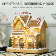 Gingerbread house lit up on a table with a Christmas festive title