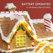 Close-up of the gingerbread house lit windows with a note that it takes 3 AA batteries