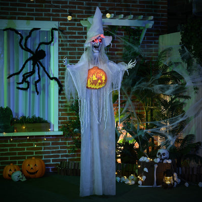 White witch decoration lit up on a porch beside cobwebs and a hanging spider