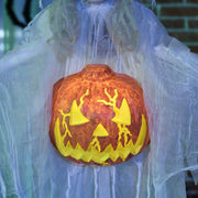 Close-up of the carved pumpkin glowing yellow at the witch's chest