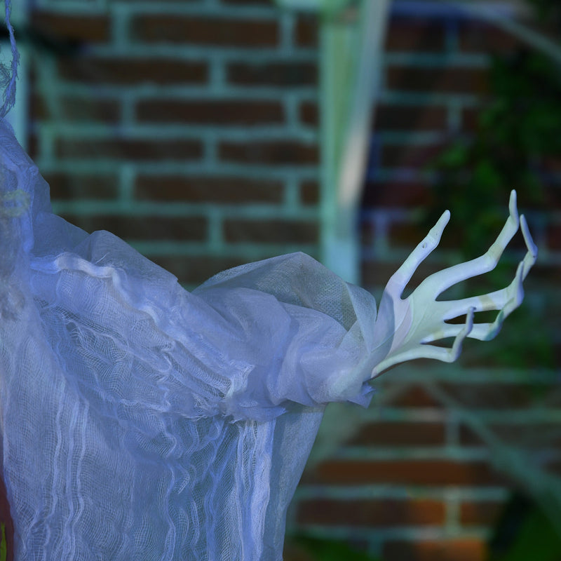 Close-up of the witch's pale bony hand against a brick wall